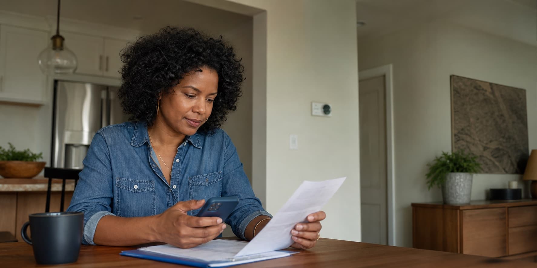 A homeowner reviewing a household bill at the kitchen table